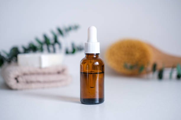 Dark glass bottle with squalane, serum, essential oil, cosmetic among spa care products. Natural organic cosmetics, eco or bio concept.