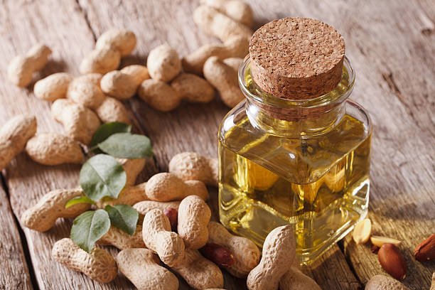 Natural peanut oil in a glass jar close up on the table. horizontal