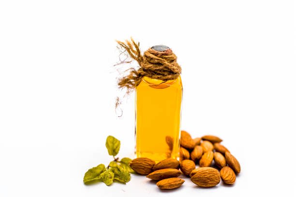 Close up of extracted oil of Almond or Badam used as hair oil for good and thicker, strong black hair isolated on withe.